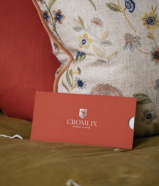 Stylish seating area in the Cromlix Hotel, Dunblane, featuring a blue sofa with colorful accents and a gallery wall of framed pictures.